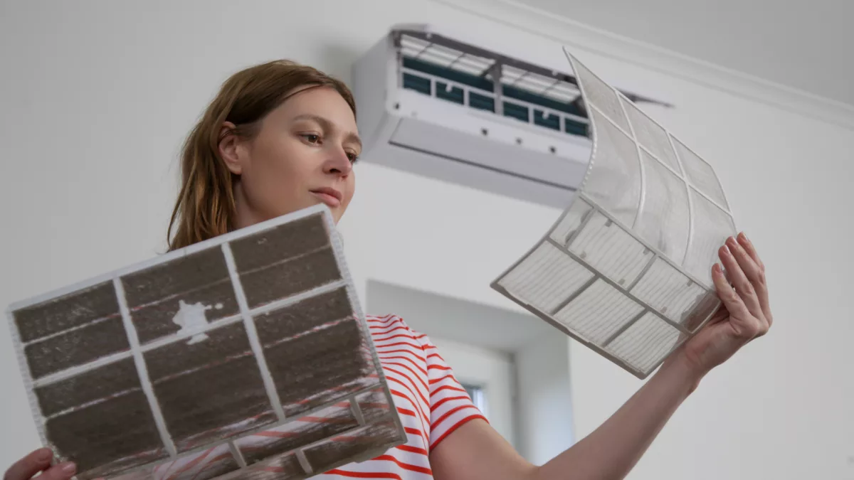 woman changing air filter in ac