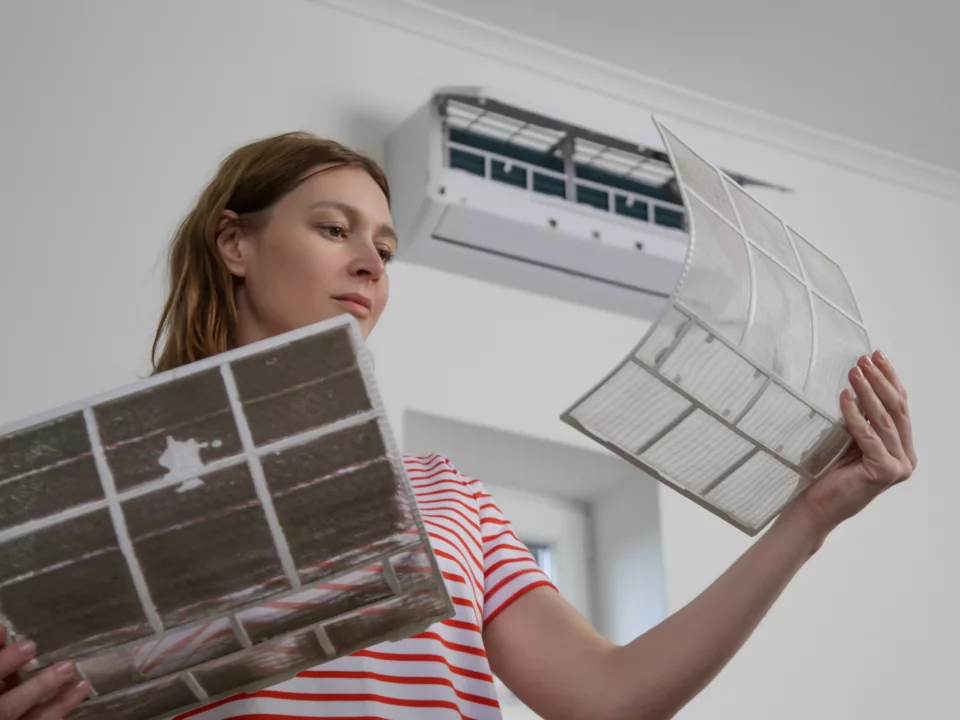 woman changing air filter in ac